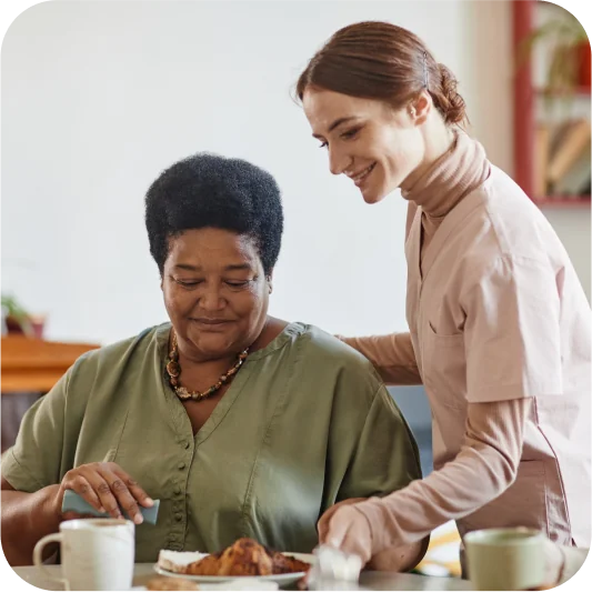 caregiver brings lunch to elderly lady